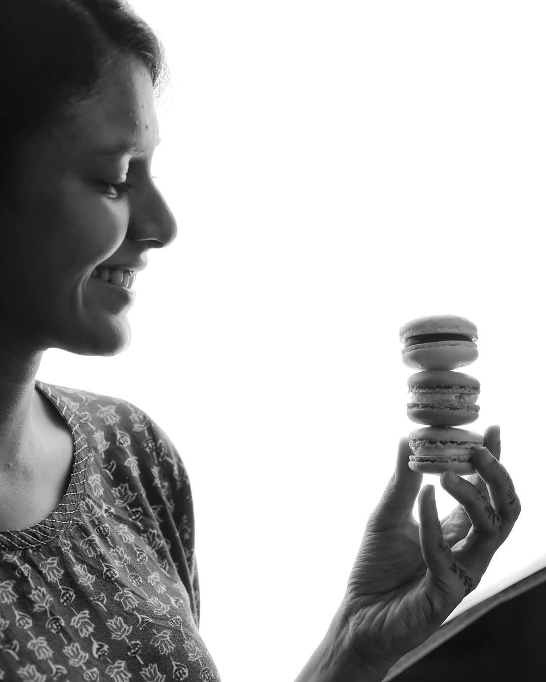Nazreen Saleem, Co-founder of Platestory, holding a stack of macarons.