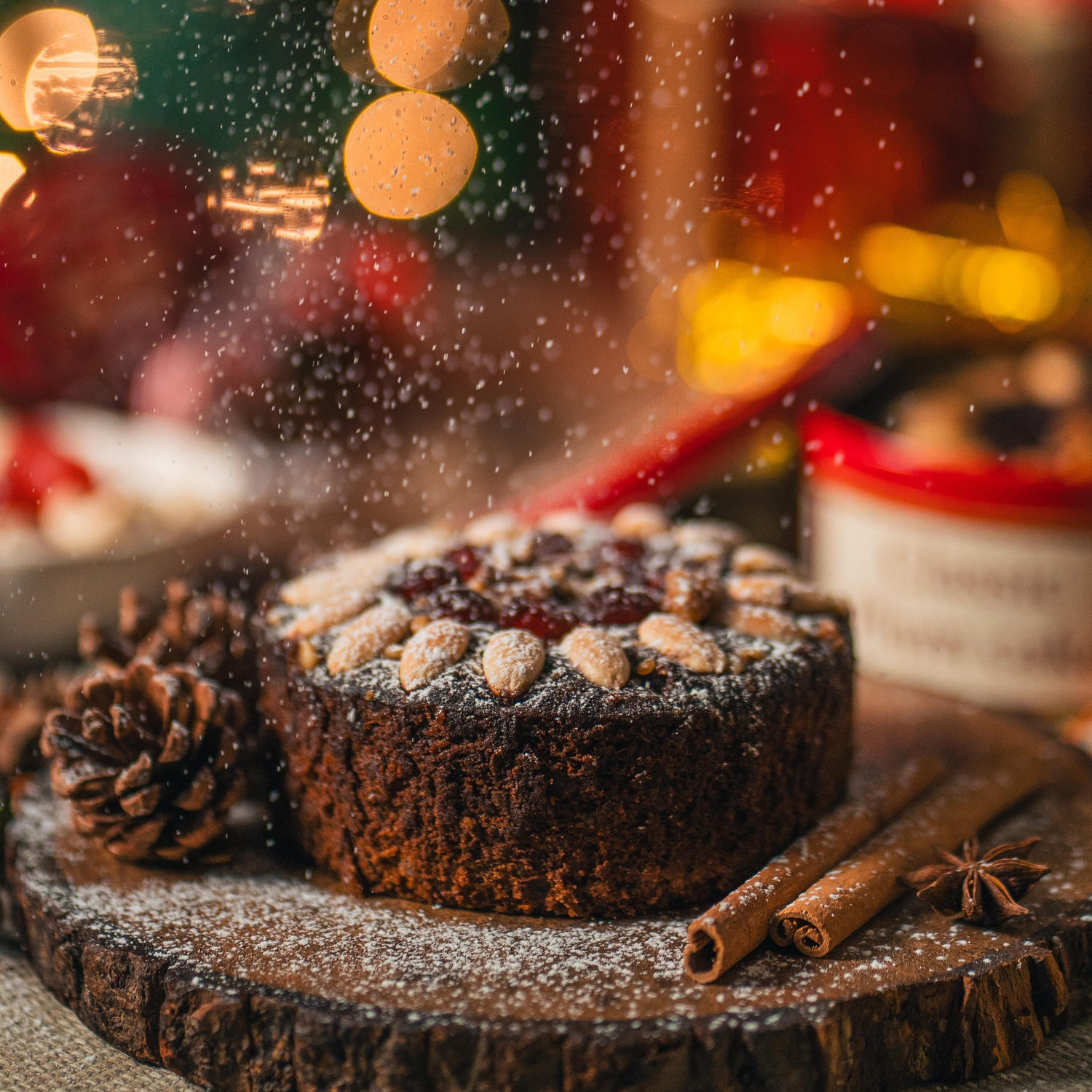 Chocolate tart with powdered sugar on a wooden board with festive lights in the background